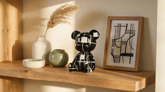 A Mosaic Bear Figurine sits on a wooden floating shelf next to a framed abstract print, a white vase with dried grass, and two small ceramic pots.