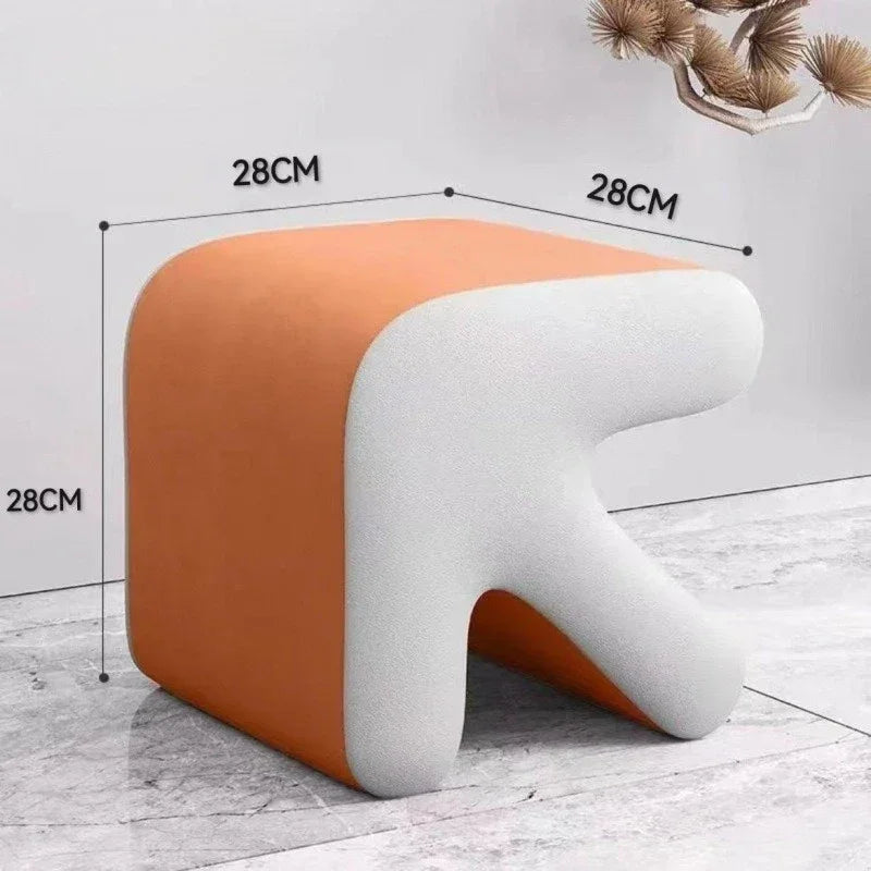 Stool with orange and white design, dimensions indicated, on a light wooden floor.