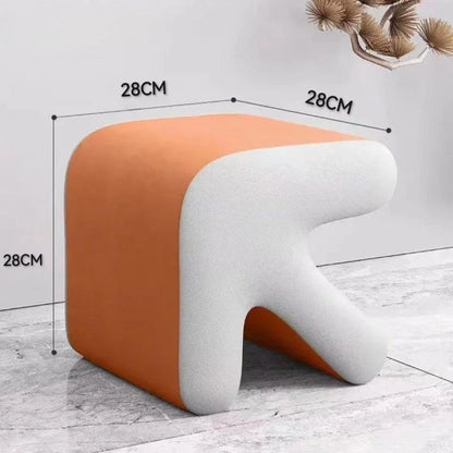 Stool with orange and white design, dimensions indicated, on a light wooden floor.