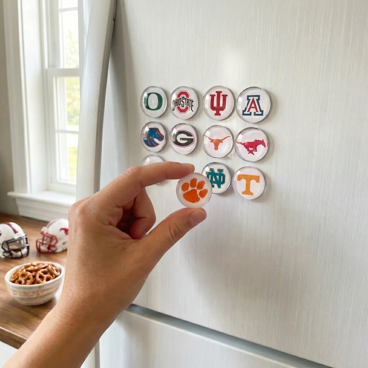 Hand College team Fridge Magnet placing sports team logos on a refrigerator door.