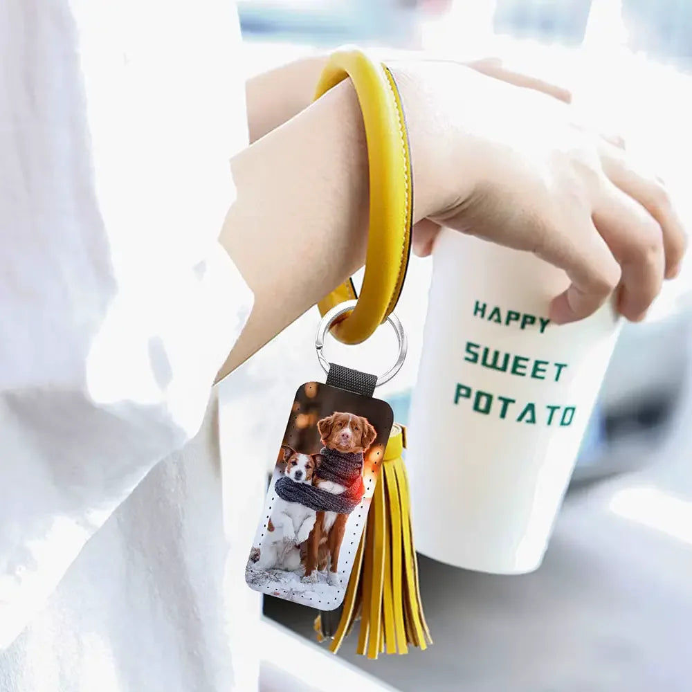 Custom Keychain with a dog photo held by a person next to a 'Happy Sweet Potato' cup.