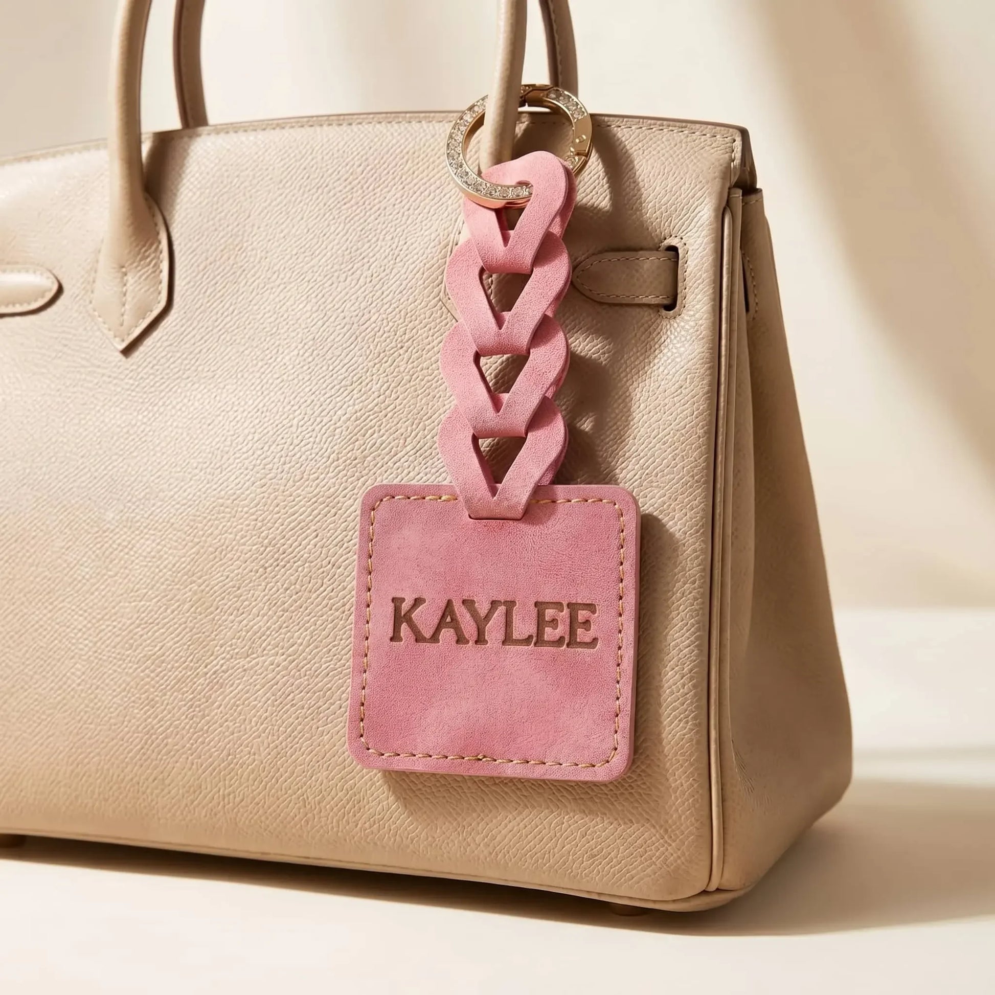 Beige handbag with a pink custom name tag attached