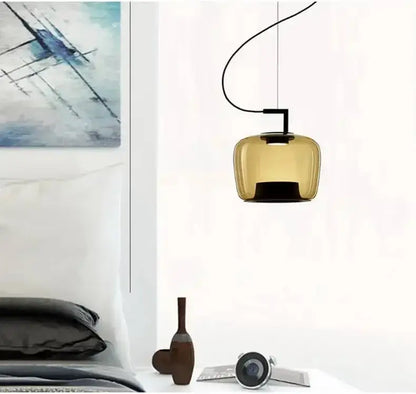Danish glass pendant light hanging above a modern bedroom decor, featuring a sculptural silhouette.