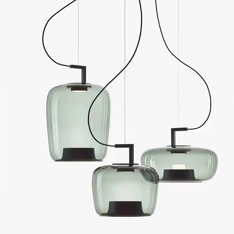 Three modern pendant lights with glass shades on a white background