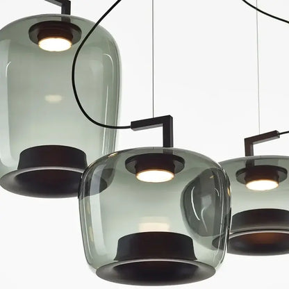 Modern chandelier with glass shades and black metal accents on a white background