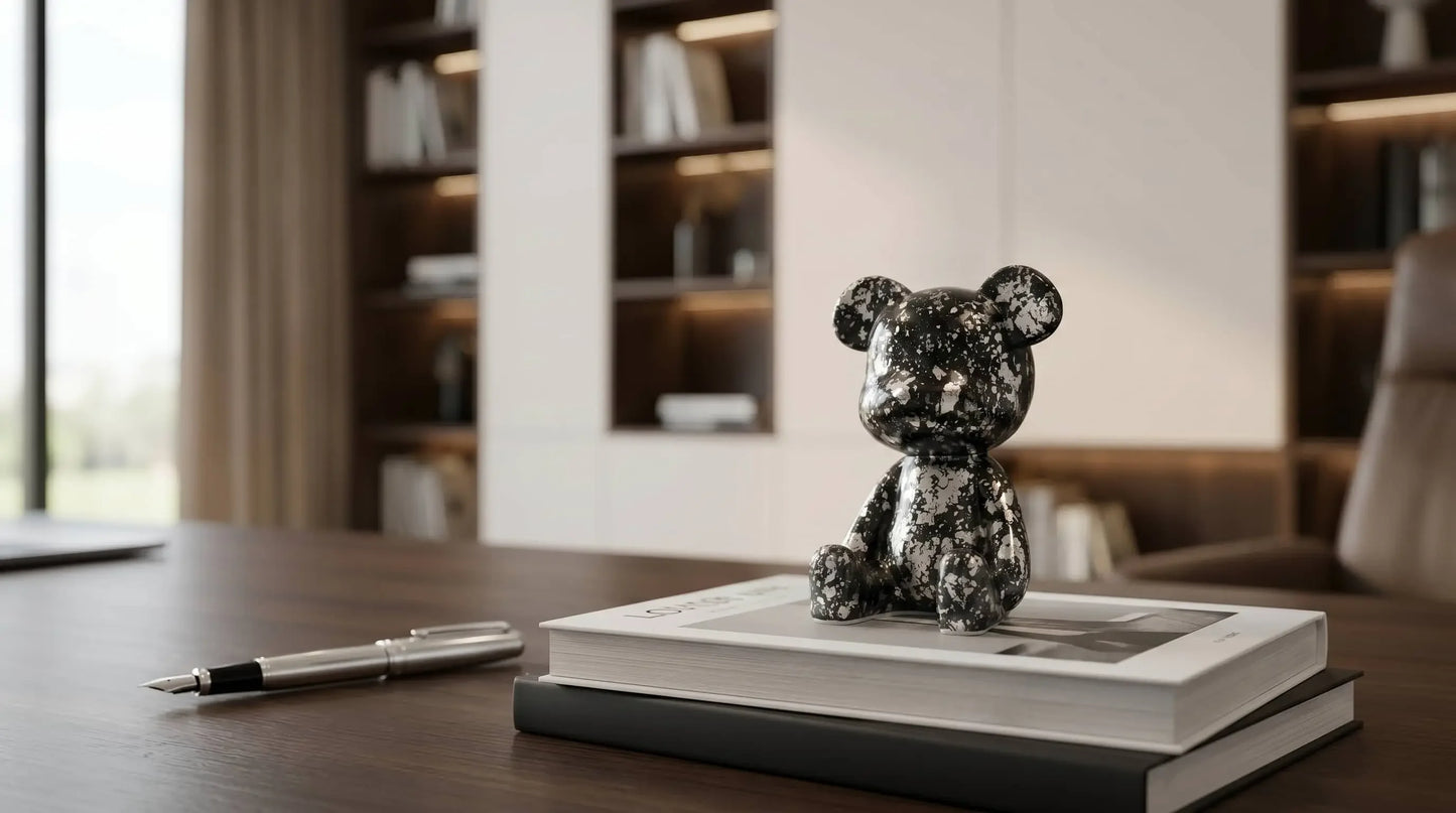 Decorative Luxe Noir Bear Figure on a book with a pen next to it in an office setting.