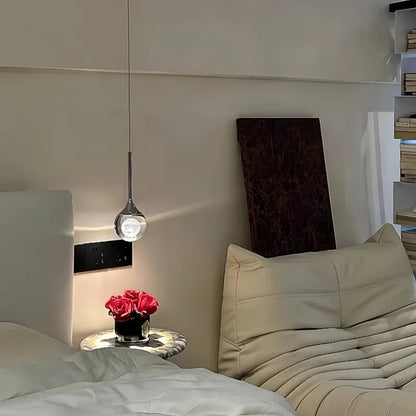 Modern bedroom with a bed, nightstand, and Modern Art Moon Pendant.