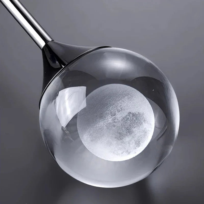 Close-up of a Modern Art Moon Pendant a clear head cover on a dark background