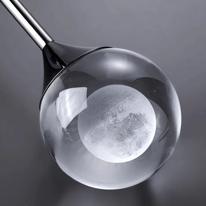Close-up of a Modern Art Moon Pendant a clear head cover on a dark background
