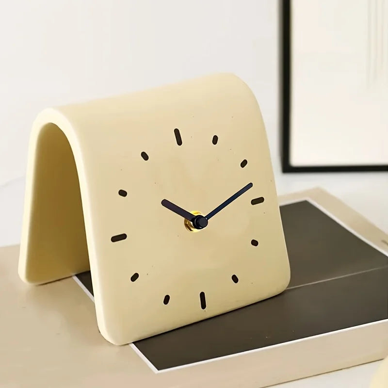 Beige clock on a surface with a white wall in the background