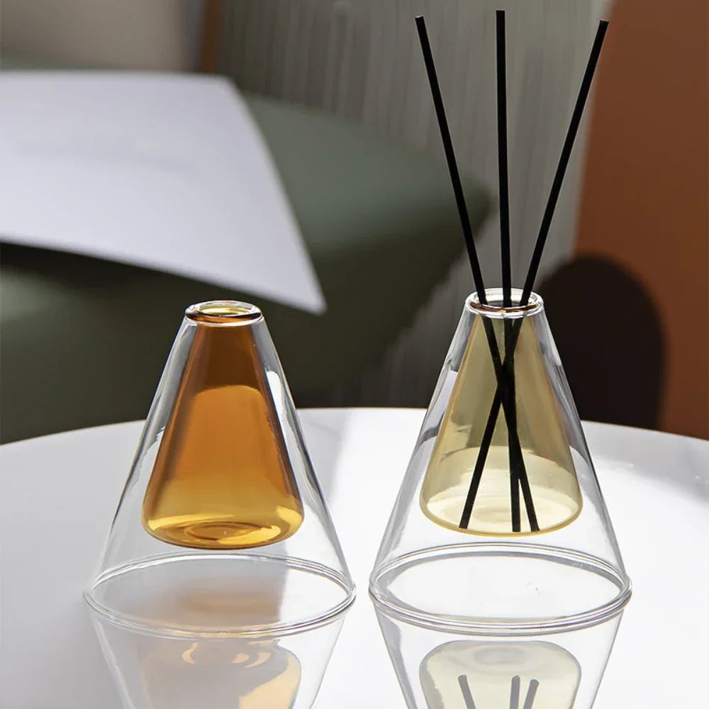 Two glass diffusers with amber-colored liquids on a white surface.