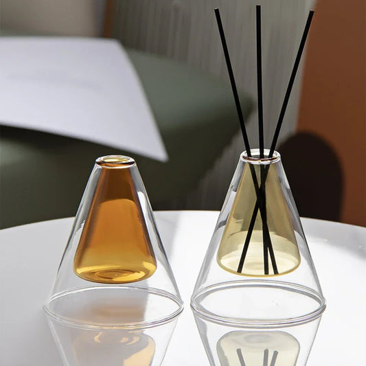 Two glass diffusers with amber-colored liquids on a white surface.