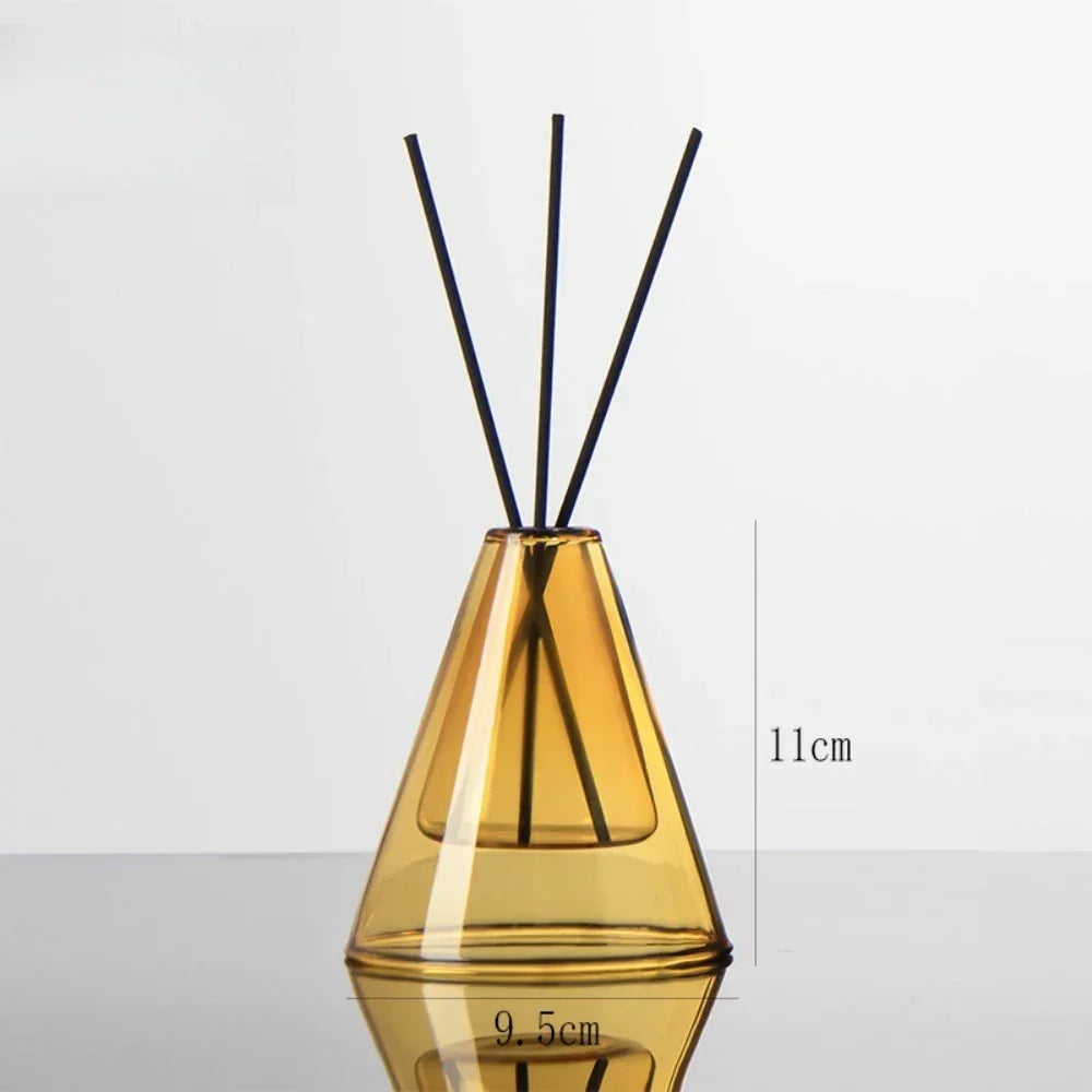 Yellow diffuser bottle with black sticks on a white background