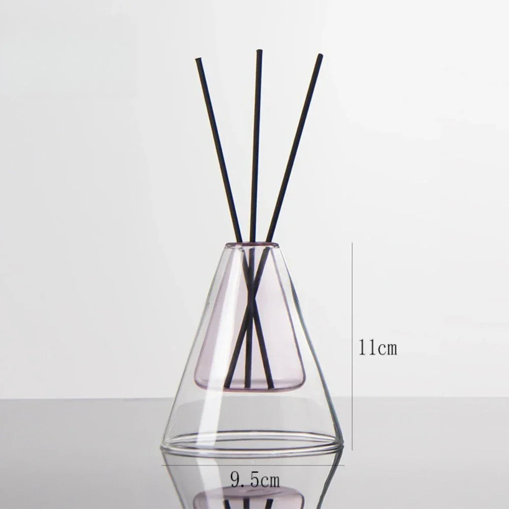Clear glass diffuser with black sticks inside on a light gray background