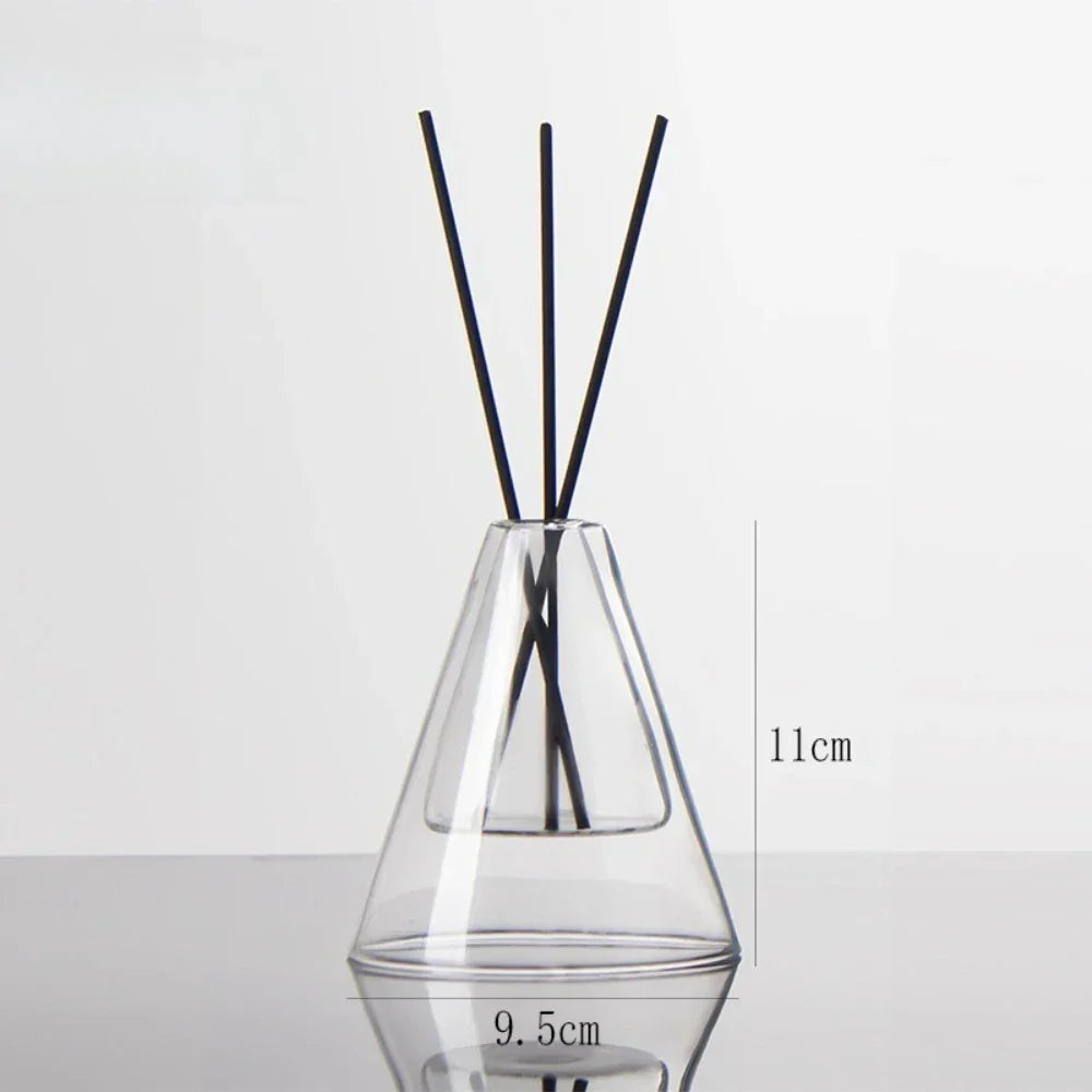 Clear glass diffuser with black sticks on a white background