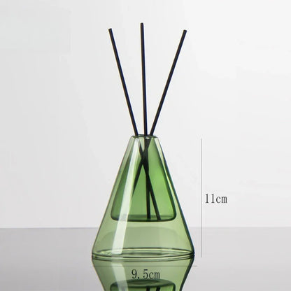 Green diffuser bottle with black sticks on a white background