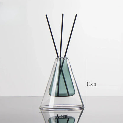 Clear glass diffuser with black sticks on a white background