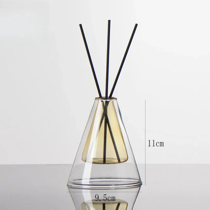 Clear glass diffuser with black sticks inside on a white background