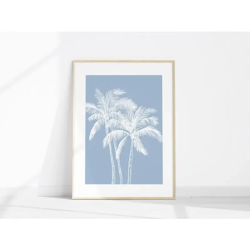 Framed artwork with white palm trees on a light blue background