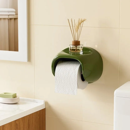 Green Vintage Roll Holder with a small plant on a beige tiled bathroom wall.